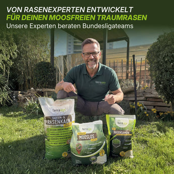 Ein lächelnder Mann mit Brille und grünem Hemd kniet im Gras hinter drei TerraUno Moosfrei Soforthilfe Set Taschen. Hinter ihm stehen eine Gartenschaukel und Bäume. Der Text darüber gibt Experten-Tipps zur Moosbekämpfung für Bundesliga-Rasen.