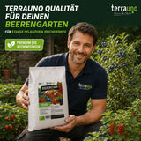 Ein lächelnder Mann kniet in einem Garten voller Beerenpflanzen und hält einen Beutel „TerraUno Beerenstark – Bio-Beerdünger“ in der Hand. Er ist umgeben von üppig blühenden Pflanzen und reifen Beeren. Das Bild unterstreicht die Qualität von TerraUno für üppig gedeihende Beergärten.