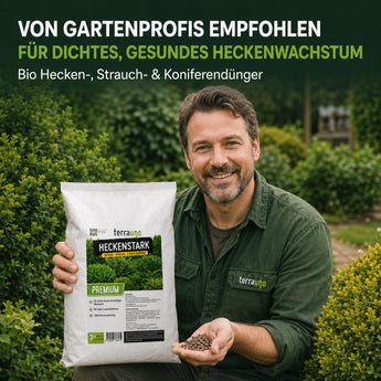 Ein lächelnder Mann in einem grünen Hemd sitzt in einem Garten und hält „TerraUno Heckenstark – Hecken-, Strauch-  Koniferendünger“ in der Hand. Der Text darüber wirbt für diesen organisch-mineralischen Dünger für dichte, gesunde Hecken – empfohlen von Gartenfachleuten.