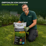 Ein lächelnder Mann mit Brille und grünem Hemd kniet auf dem Rasen und hält einen großen Sack „TerraUno Rasenerde torffrei“ in der Hand. Die Bildunterschrift lautet: „Empfohlen von unserem Rasenexperten.“ Die Gartenpflanzen im Hintergrund bilden den perfekten Rahmen für die Nachsaat von Rasensamen oder die Neuanlage eines Rasens.