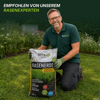 Ein lächelnder Mann mit Brille und grünem Hemd kniet auf dem Rasen und hält einen großen Sack „TerraUno Rasenerde torffrei“ in der Hand. Die Bildunterschrift lautet: „Empfohlen von unserem Rasenexperten.“ Die Gartenpflanzen im Hintergrund bilden den perfekten Rahmen für die Nachsaat von Rasensamen oder die Neuanlage eines Rasens.